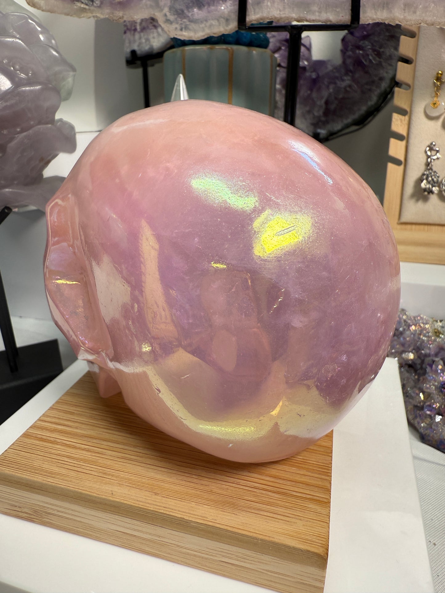 Large Pink Aura Rose Quartz crystal skull, measuring approximately 5 x 5.5 inches and weighing 4 lbs. Features soft pink coloration and a glowing, iridescent surface. Displayed as a carved decorative stone with heart-focused elegance.