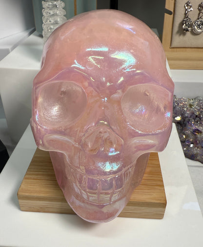Large Pink Aura Rose Quartz crystal skull, measuring approximately 5 x 5.5 inches and weighing 4 lbs. Features soft pink coloration and a glowing, iridescent surface. Displayed as a carved decorative stone with heart-focused elegance.