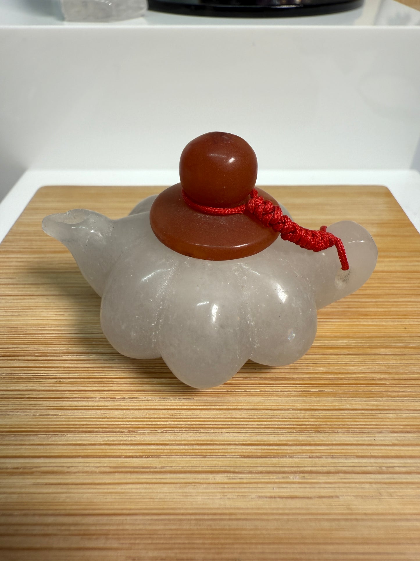 White Jade crystal teapot figurine, 2 inches long, carved in a Pumpkin teapot shape with a soft, milky white finish. Displayed as an elegant decorative accent.