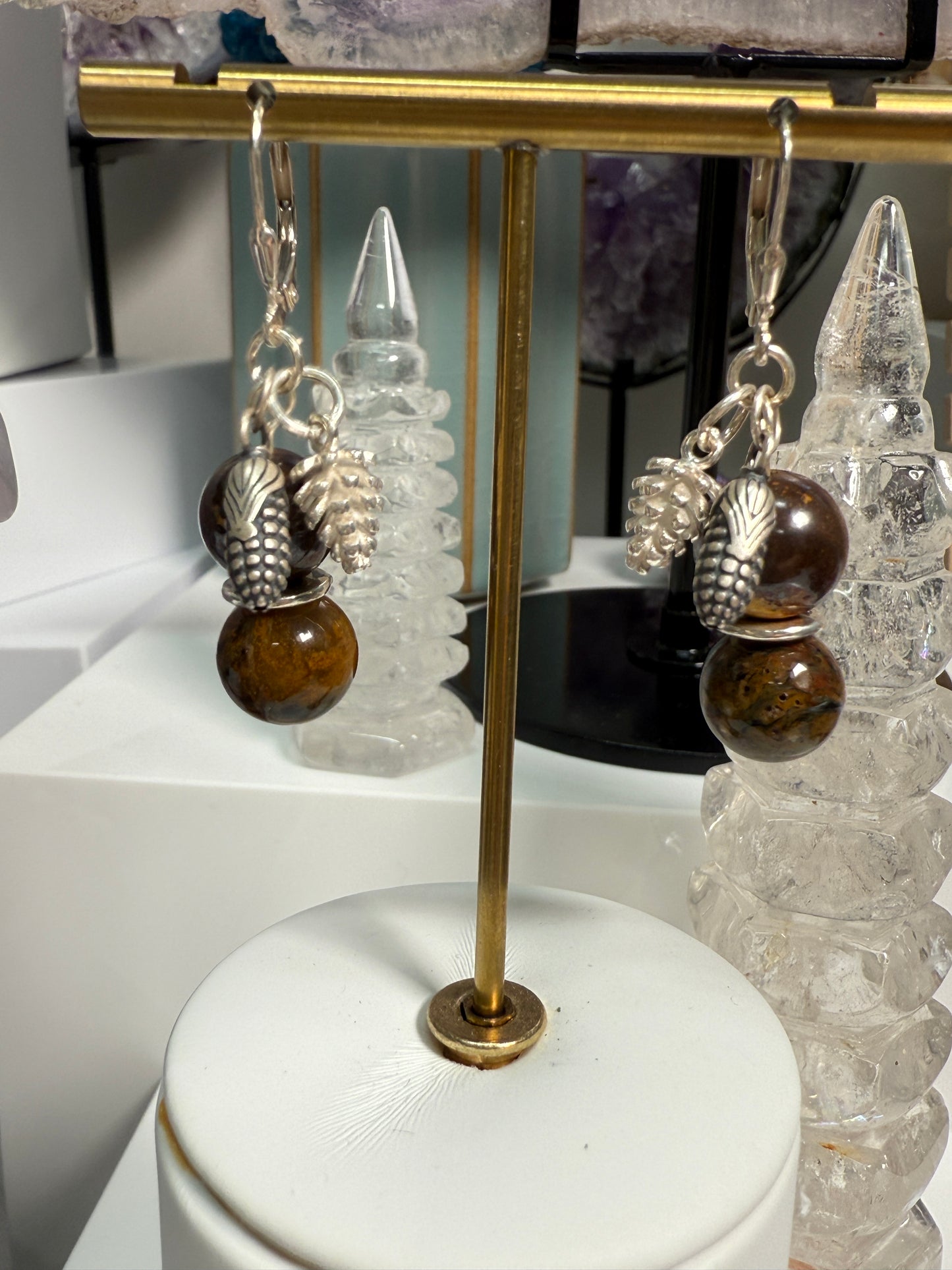 Earrings with round Brown Opal and Pietersite stones, finished with detailed silver pine cone and corn cob motifs. Styled as earthy, fall-inspired jewelry.