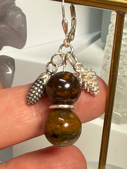Earrings with round Brown Opal and Pietersite stones, finished with detailed silver pine cone and corn cob motifs. Styled as earthy, fall-inspired jewelry.