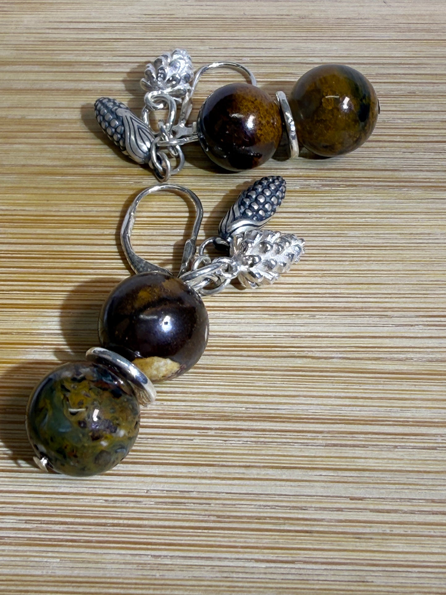 Earrings with round Brown Opal and Pietersite stones, finished with detailed silver pine cone and corn cob motifs. Styled as earthy, fall-inspired jewelry.