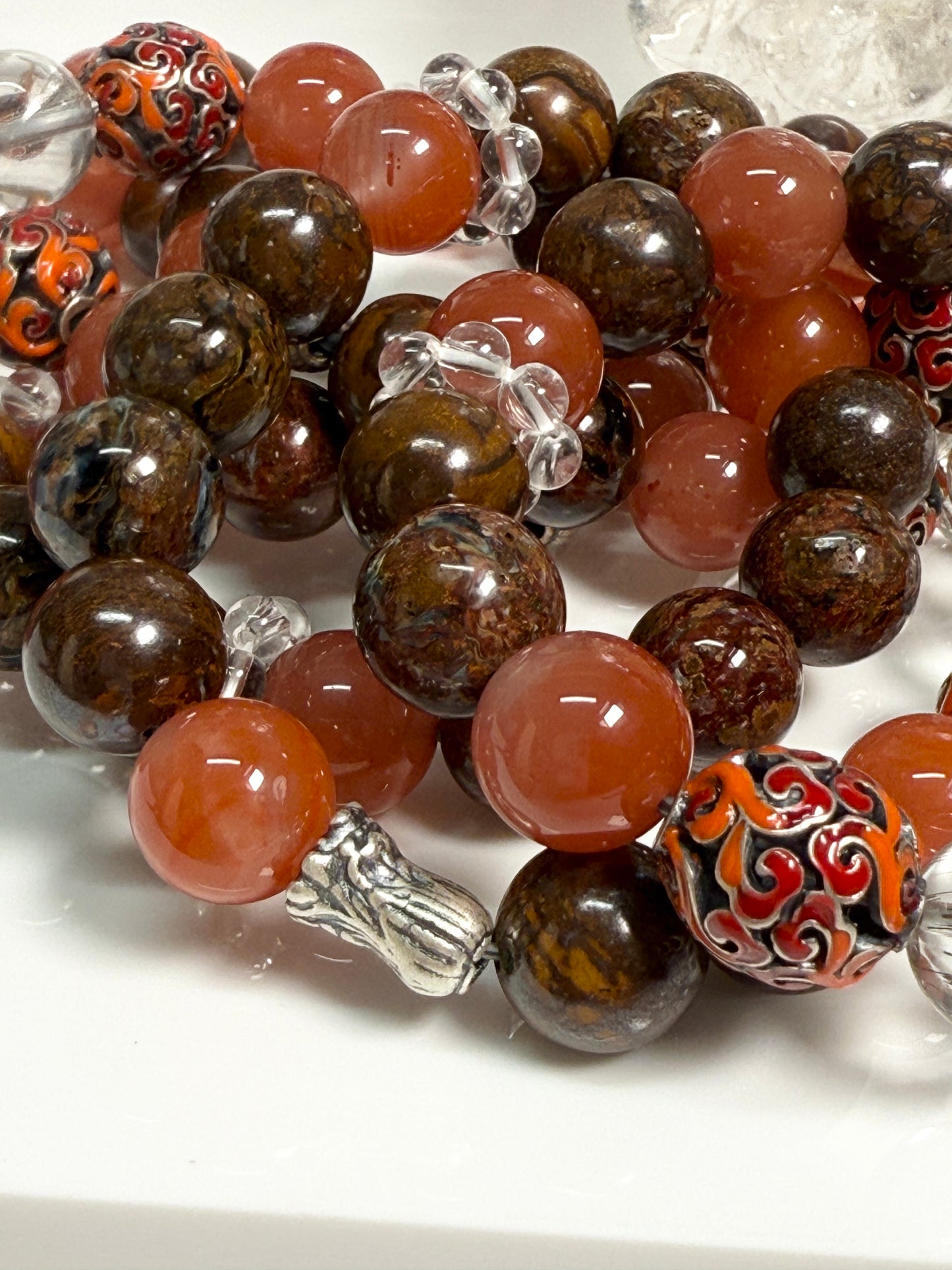 Crystal bracelet featuring South Red Agate, Pietersite, Rutile-in-Quartz, and Brown Opal, with 925 sterling silver cabbage and enameled beads, accented by a clear quartz ring. A sculptural fine jewelry piece symbolizing growth, clarity, and inner resilience.